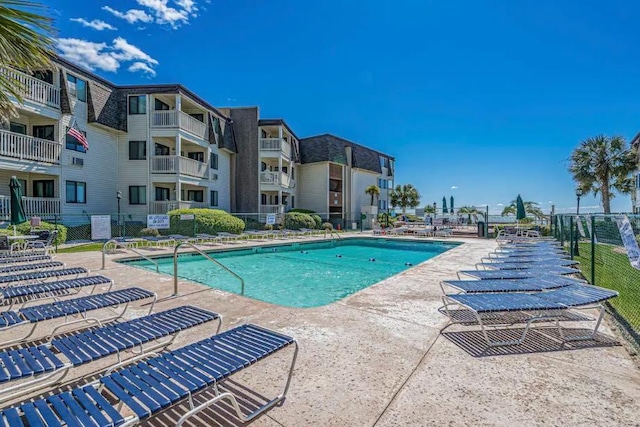 community pool featuring a patio and fence