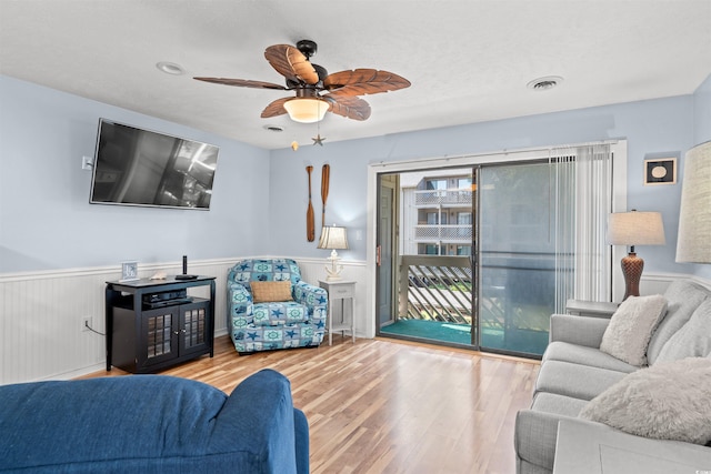 living room featuring ceiling fan and light hardwood / wood-style flooring