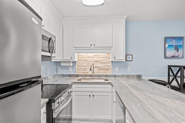 kitchen with white cabinetry, sink, stainless steel appliances, and light stone countertops