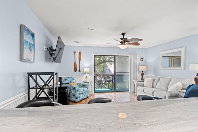 living room featuring ceiling fan and hardwood / wood-style flooring