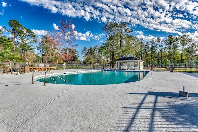 community pool featuring a patio and fence