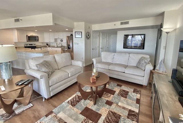 living room with dark wood-type flooring and sink