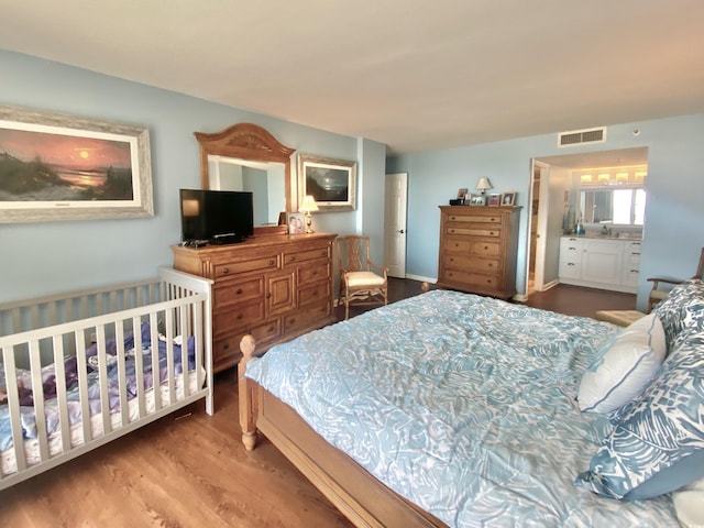 bedroom with hardwood / wood-style flooring and sink