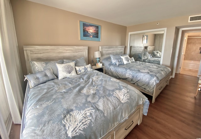 bedroom with a closet and dark hardwood / wood-style floors