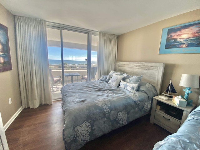 bedroom with floor to ceiling windows, dark hardwood / wood-style floors, and access to outside