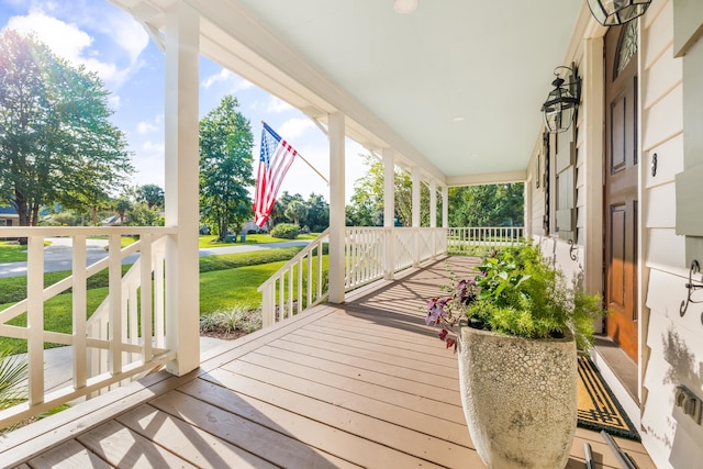 wooden deck with a lawn and a porch