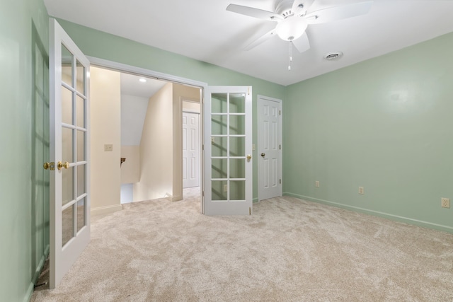 unfurnished bedroom featuring french doors, light colored carpet, a closet, and ceiling fan