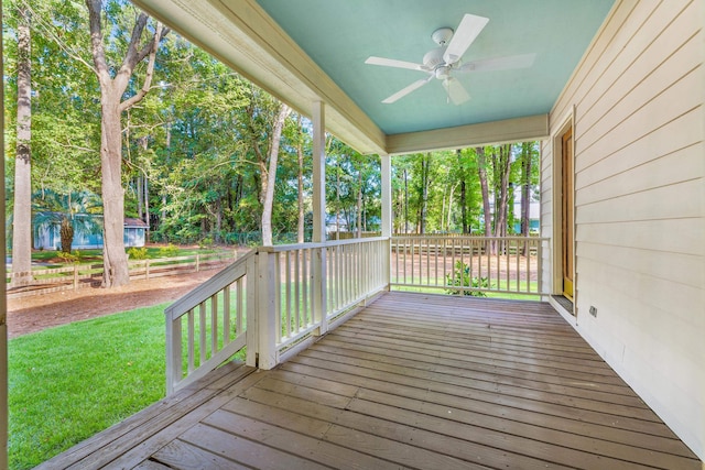 deck featuring ceiling fan and a yard