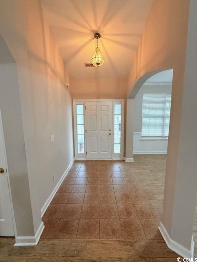 tiled foyer entrance with lofted ceiling and a wealth of natural light