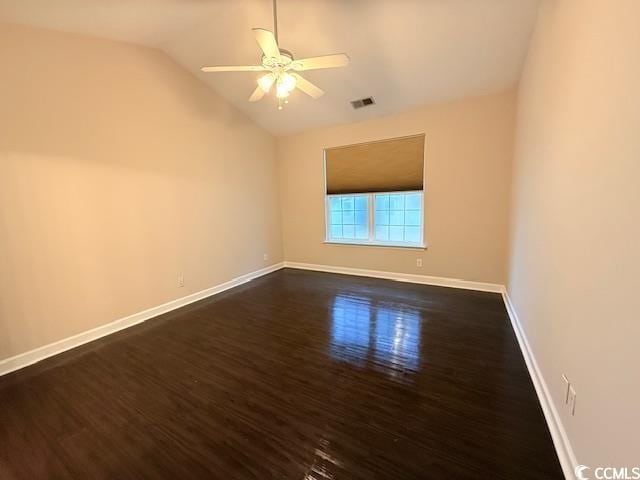 empty room featuring lofted ceiling, dark wood-type flooring, and ceiling fan