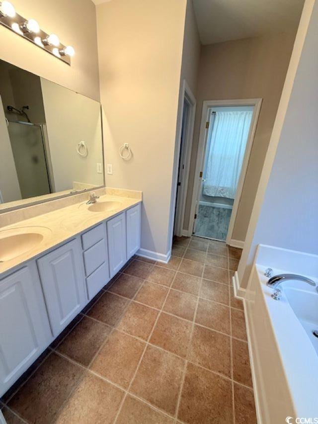 bathroom with tile patterned flooring, vanity, and shower with separate bathtub