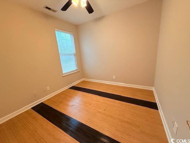 unfurnished room with hardwood / wood-style floors and ceiling fan