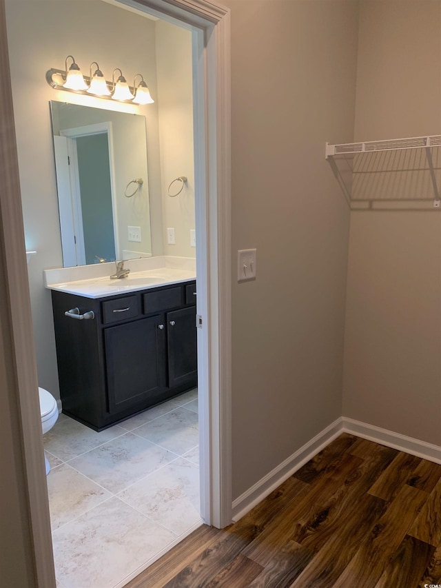 bathroom featuring toilet, vanity, and wood-type flooring