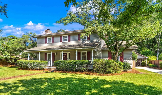 view of front of house with a front yard and covered porch