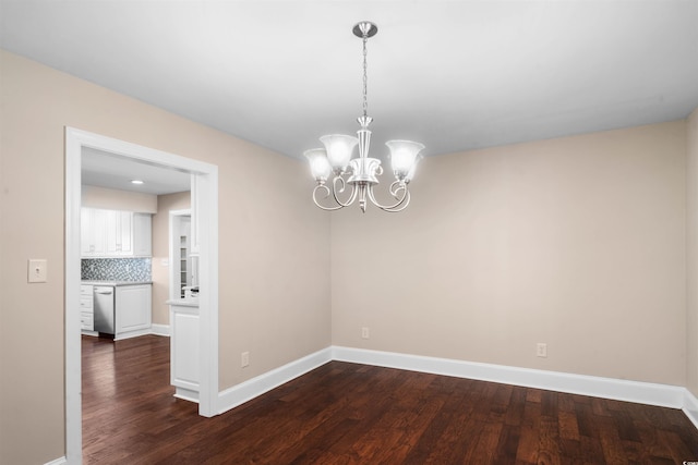 unfurnished room featuring a chandelier and dark hardwood / wood-style floors