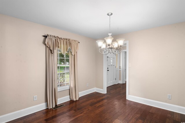 unfurnished dining area with a notable chandelier and dark hardwood / wood-style flooring