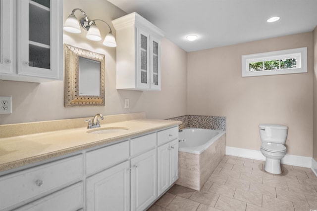 bathroom featuring vanity, toilet, tiled bath, and tile patterned flooring