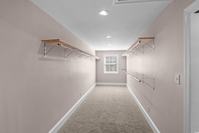 walk in closet with light colored carpet