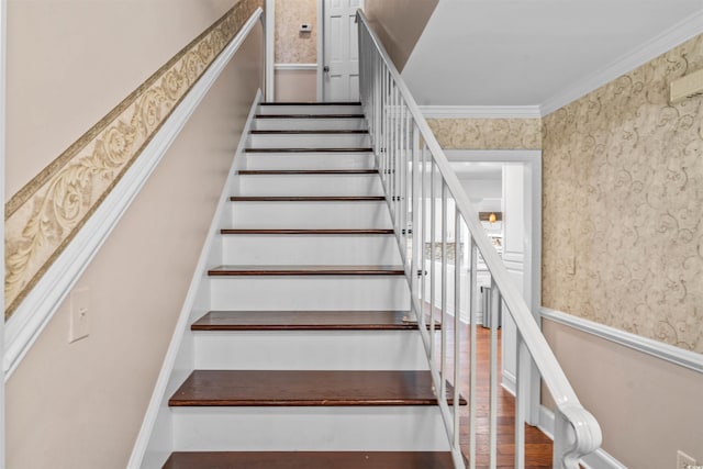 staircase with hardwood / wood-style floors and crown molding