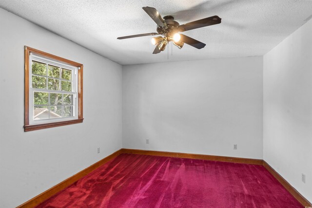 spare room with a textured ceiling, carpet floors, and ceiling fan