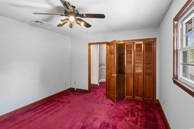 unfurnished bedroom featuring a textured ceiling, carpet floors, a closet, and ceiling fan