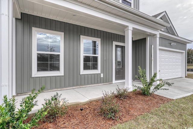 property entrance featuring covered porch and a garage