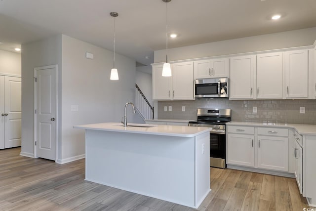 kitchen with pendant lighting, sink, white cabinetry, and stainless steel appliances