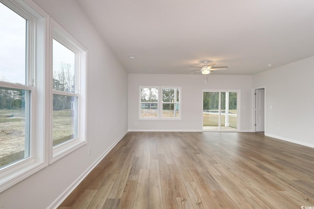 empty room featuring plenty of natural light, light hardwood / wood-style floors, and ceiling fan