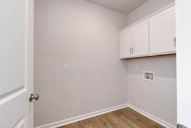 laundry room featuring hardwood / wood-style floors, cabinets, and washer hookup