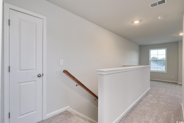 hall with light colored carpet