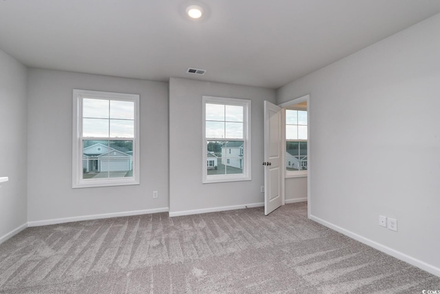 carpeted empty room featuring plenty of natural light