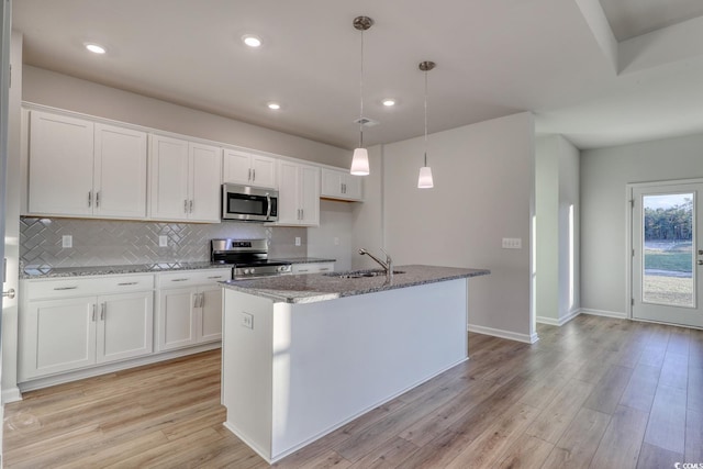 kitchen featuring white cabinetry, an island with sink, and stainless steel appliances