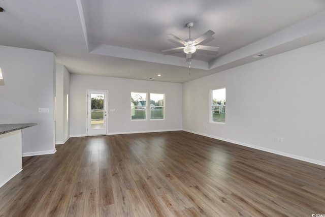 unfurnished room featuring wood-type flooring, a raised ceiling, and ceiling fan