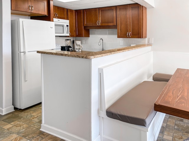 kitchen with backsplash and white appliances