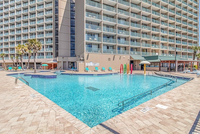 view of swimming pool featuring a hot tub