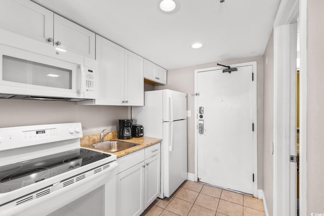 kitchen with white cabinets, white appliances, light tile patterned floors, and sink