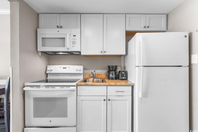 kitchen with white cabinets, sink, and white appliances