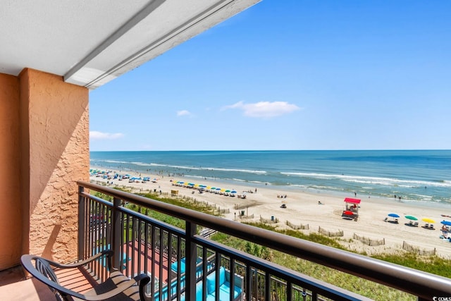 balcony featuring a water view and a beach view