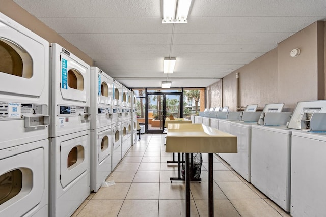 laundry room featuring washing machine and dryer, light tile patterned floors, and stacked washer and clothes dryer