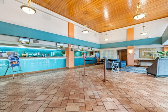 interior space with wooden ceiling, a towering ceiling, and a swimming pool