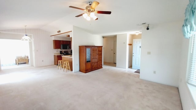 unfurnished living room featuring lofted ceiling, ceiling fan, and light colored carpet