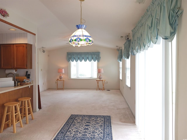 carpeted dining area featuring lofted ceiling and sink