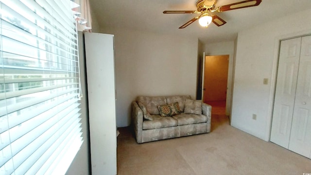 living area featuring ceiling fan and light colored carpet