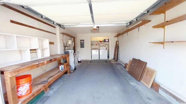 garage featuring a garage door opener, washing machine and clothes dryer, electric panel, and a workshop area