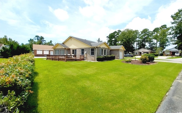 rear view of house with a yard, a garage, and a wooden deck