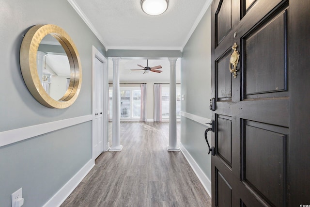 entrance foyer featuring ceiling fan, hardwood / wood-style flooring, a textured ceiling, ornamental molding, and decorative columns