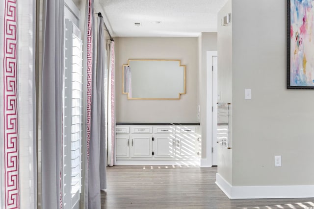 hall with dark hardwood / wood-style floors and a textured ceiling