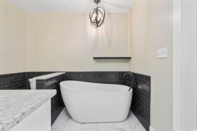 bathroom featuring an inviting chandelier, tile walls, and a tub to relax in