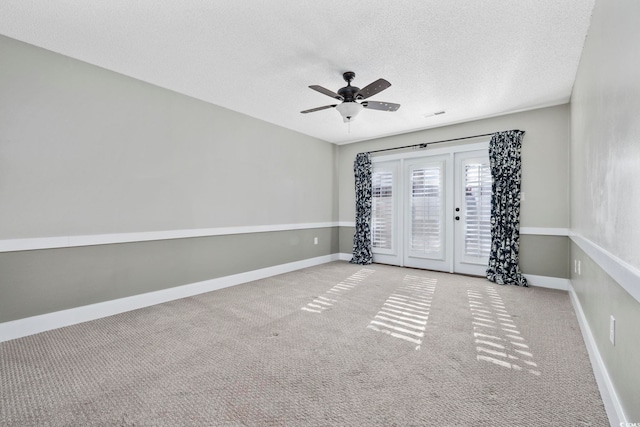 carpeted empty room with ceiling fan and a textured ceiling