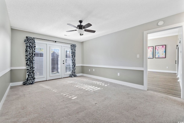 carpeted spare room with ceiling fan and a textured ceiling